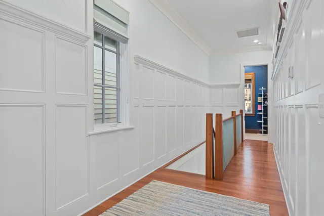 a view of a hallway with wooden floor and staircase