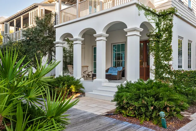 a front view of a house with a front door and potted plants