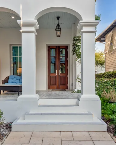a view of a patio with couches table and chairs and potted plants