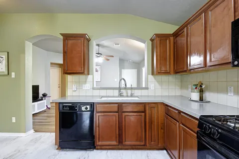 a kitchen with stainless steel appliances granite countertop a sink stove and cabinets