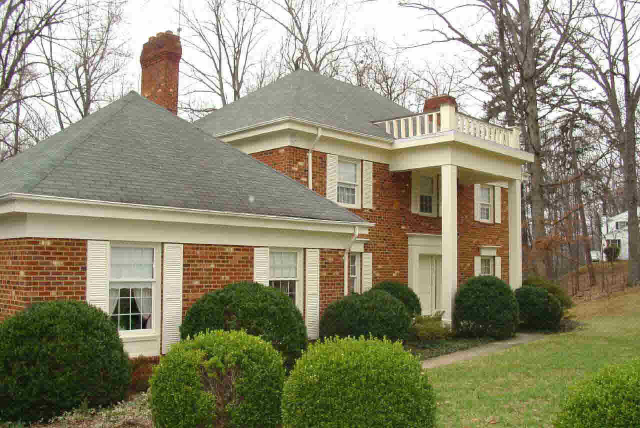 a front view of a house with a yard and potted plants