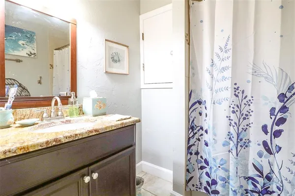 a bathroom with a granite countertop sink and a mirror