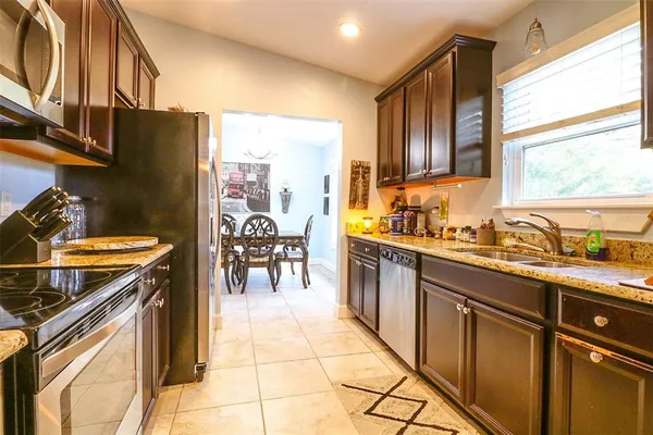 a kitchen with stainless steel appliances granite countertop a stove a sink and a microwave