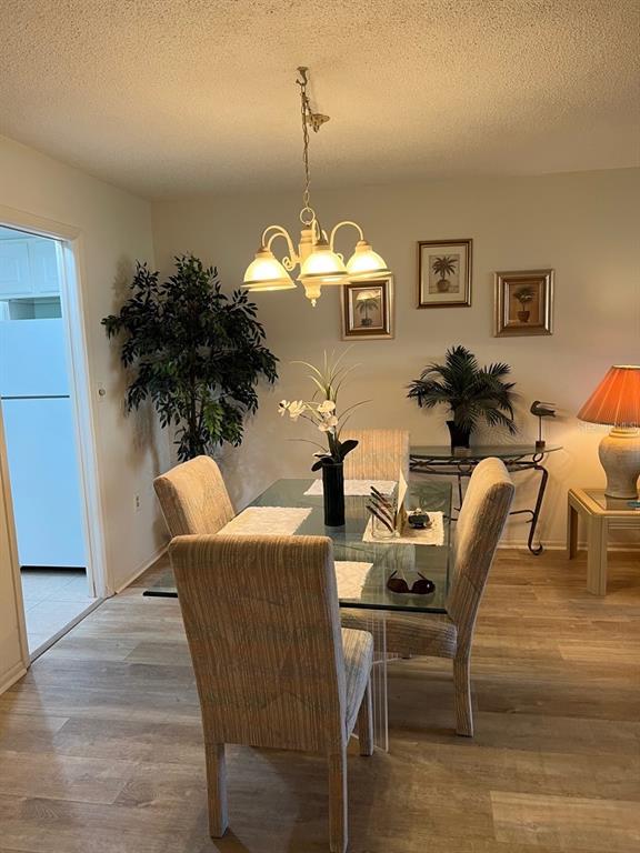 4725 Cove Circle, Unit 108 St. Petersburg, FL 33708 - Photo 4 of 14 a view of a dining room with furniture and wooden floor