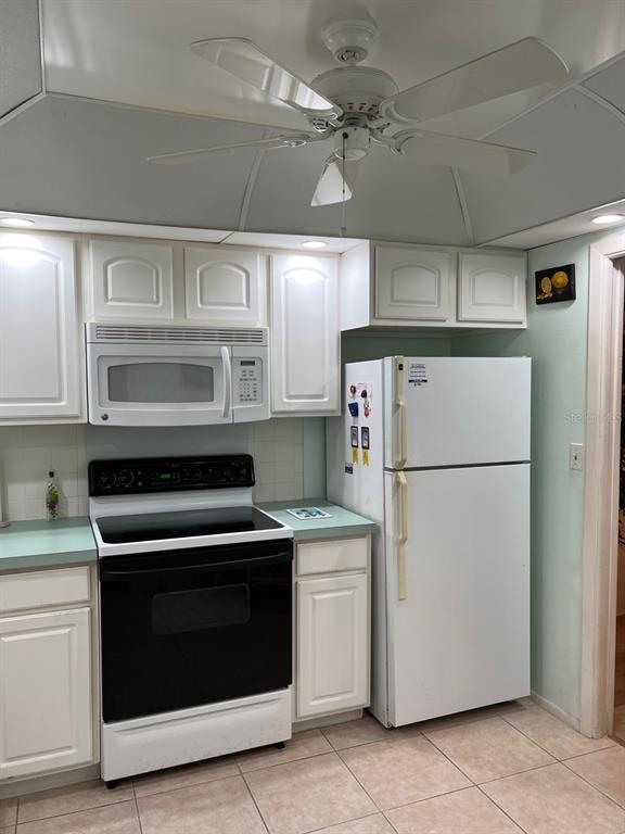 4725 Cove Circle, Unit 108 St. Petersburg, FL 33708 - Photo 6 of 14 a kitchen with cabinets and stainless steel appliances