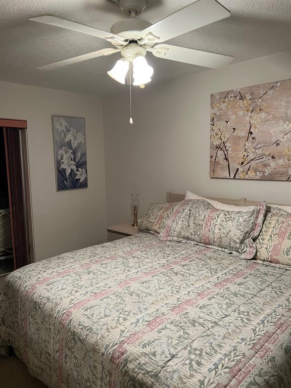 4725 Cove Circle, Unit 108 St. Petersburg, FL 33708 - Photo 7 of 14 a large bed sitting in a bedroom and a chandelier