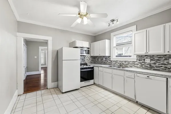 a kitchen with white cabinets and white appliances
