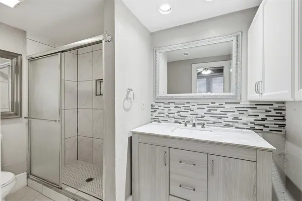 a bathroom with a shower sink and mirror