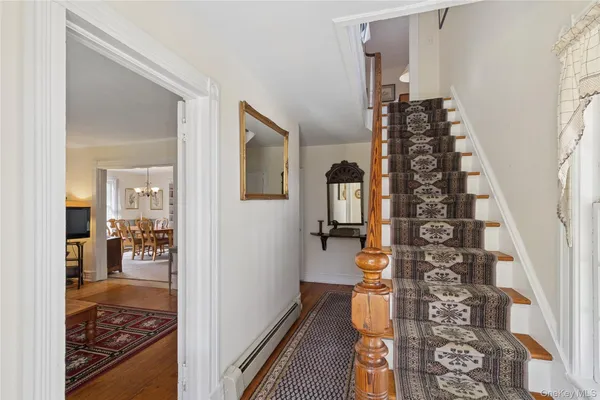 a view of a hallway with wooden floor and a living room