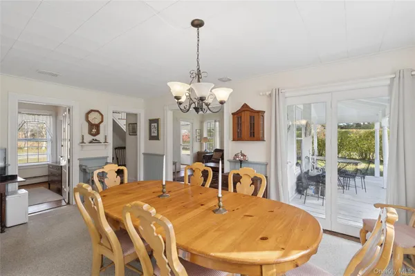 a view of a dining room with furniture a chandelier and wooden floor