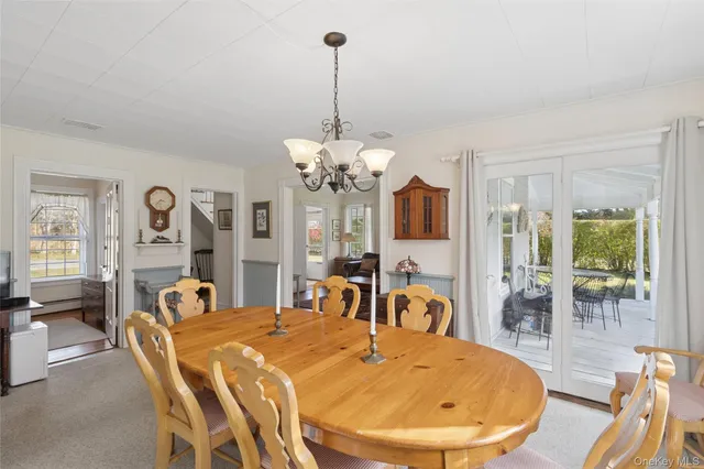 a view of a dining room with furniture a chandelier and wooden floor