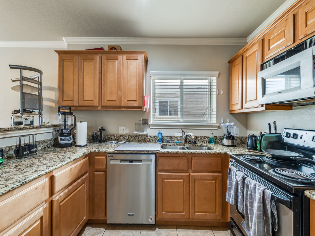 3007 Speedway, Unit 4 Austin, TX 78705 - Photo 5 of 25 a kitchen with stainless steel appliances granite countertop a stove a sink dishwasher and cabinets with wooden floor