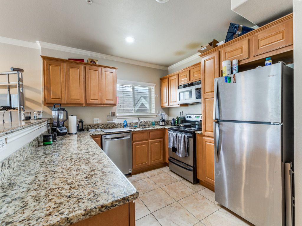 3007 Speedway, Unit 4 Austin, TX 78705 - Photo 8 of 25 a kitchen with granite countertop stainless steel appliances a refrigerator stove top oven and sink