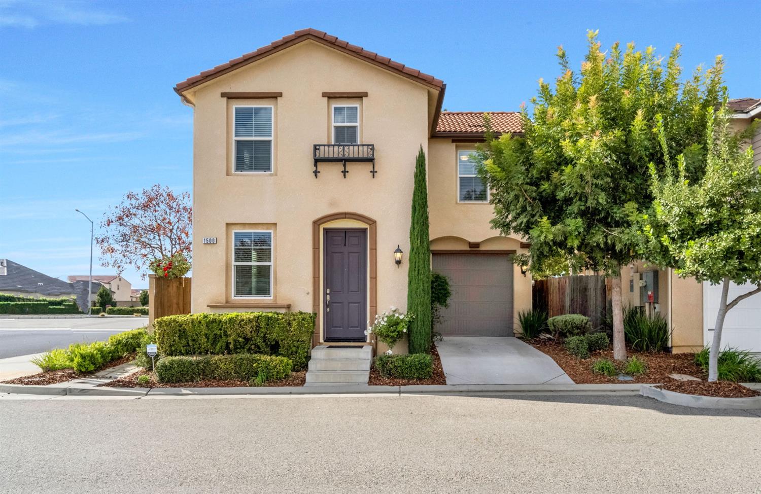 a front view of a house with a yard and potted plants