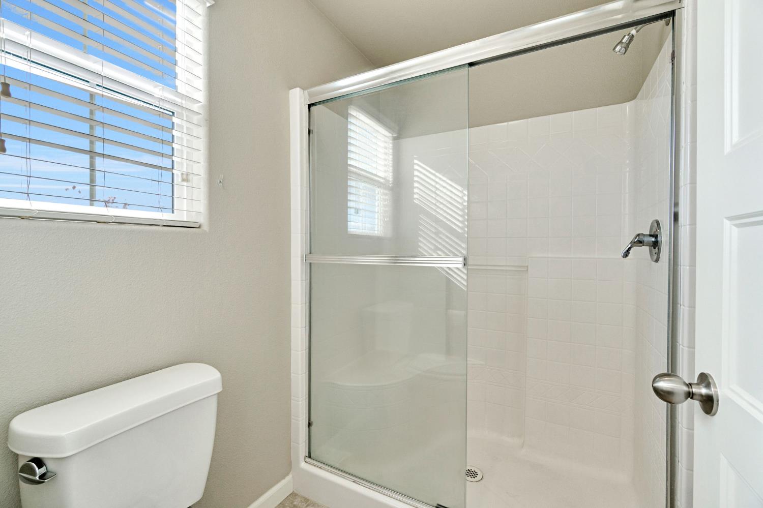 1500 North Encoure Way Clovis, CA 93619 - Photo 20 of 37 a bathroom with a toilet and a shower