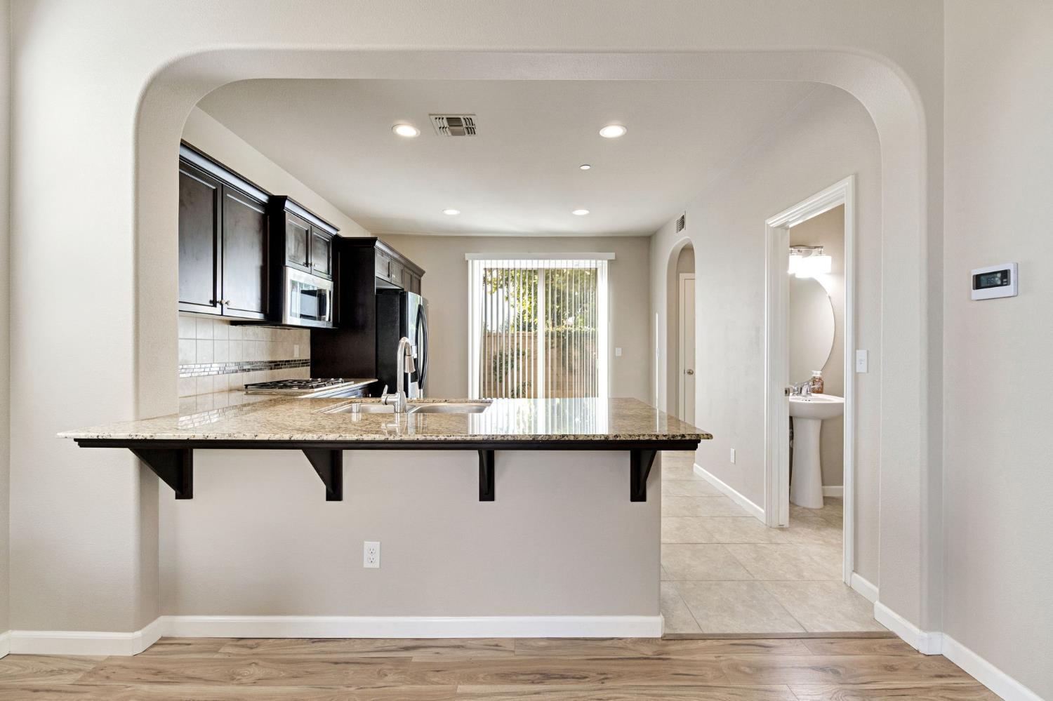 1500 North Encoure Way Clovis, CA 93619 - Photo 7 of 37 a kitchen with stainless steel appliances granite countertop a sink and stove