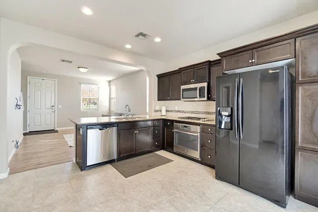 a large kitchen with cabinets and stainless steel appliances