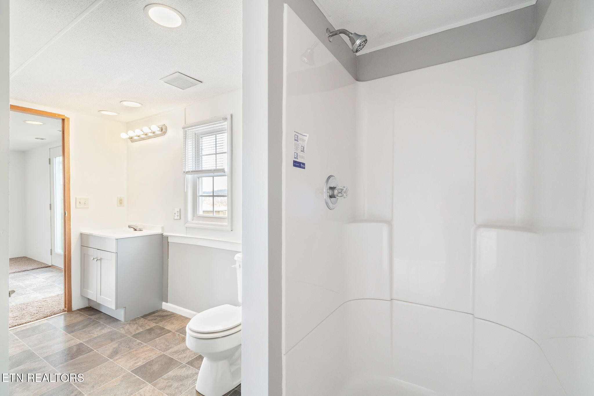 361 Doane Road New Market, TN 37820 - Photo 21 of 39 a bathroom with a granite countertop sink a toilet and shower