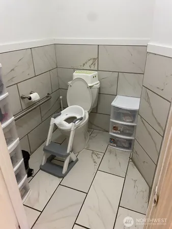 a bathroom with a toilet and a washing machine in a bathroom