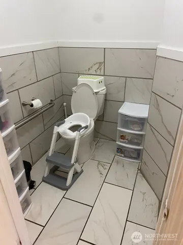 a bathroom with a toilet and a washing machine in a bathroom