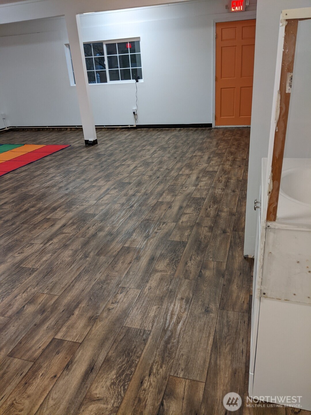 105 Northeast 193rd Street Shoreline, WA 98155 - Photo 7 of 10 a view of an empty room with wooden floor and a window