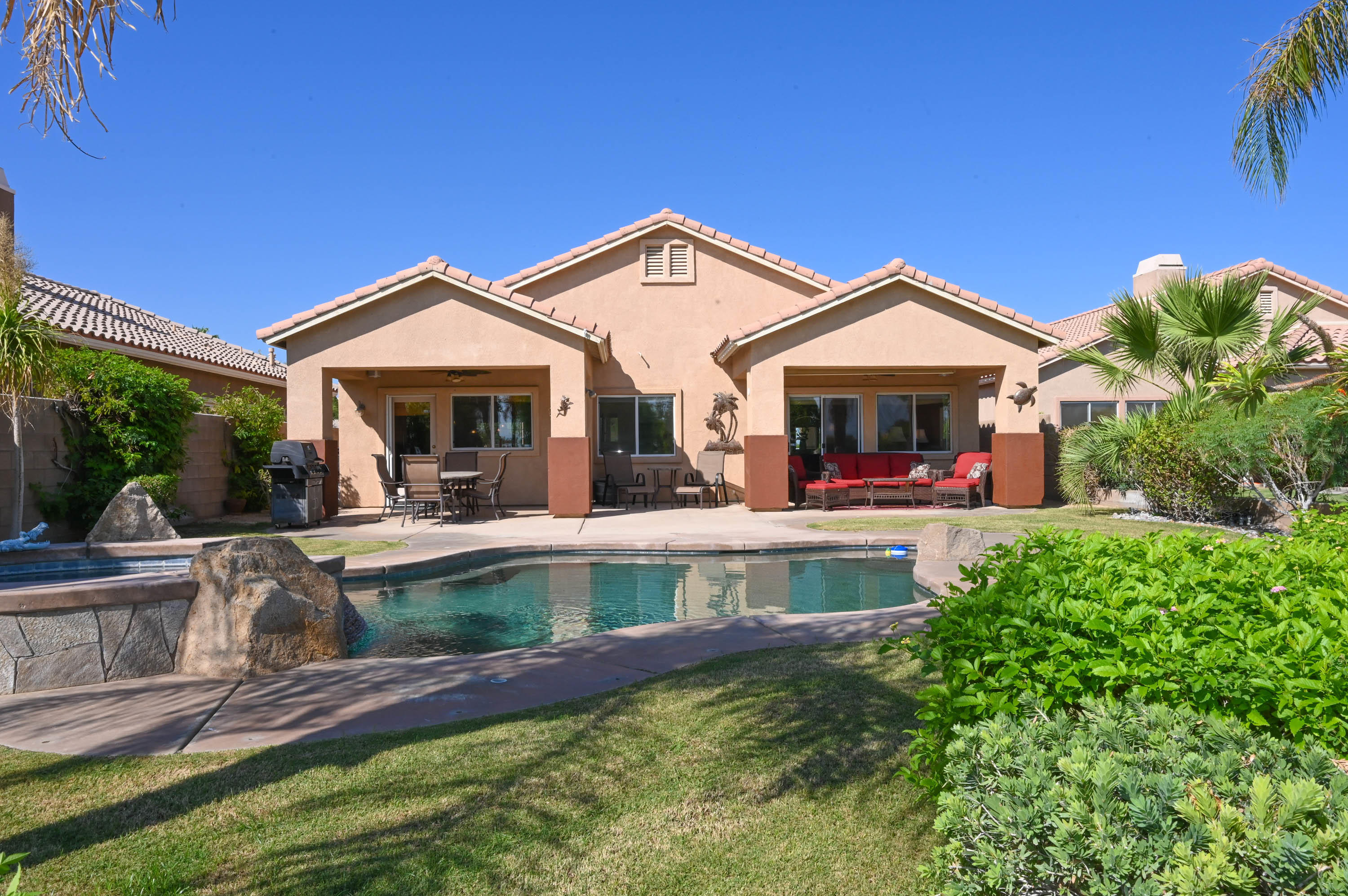 45204 Banff Springs Street Indio, CA 92201 - Photo 3 of 36 a view of a house with pool and chairs
