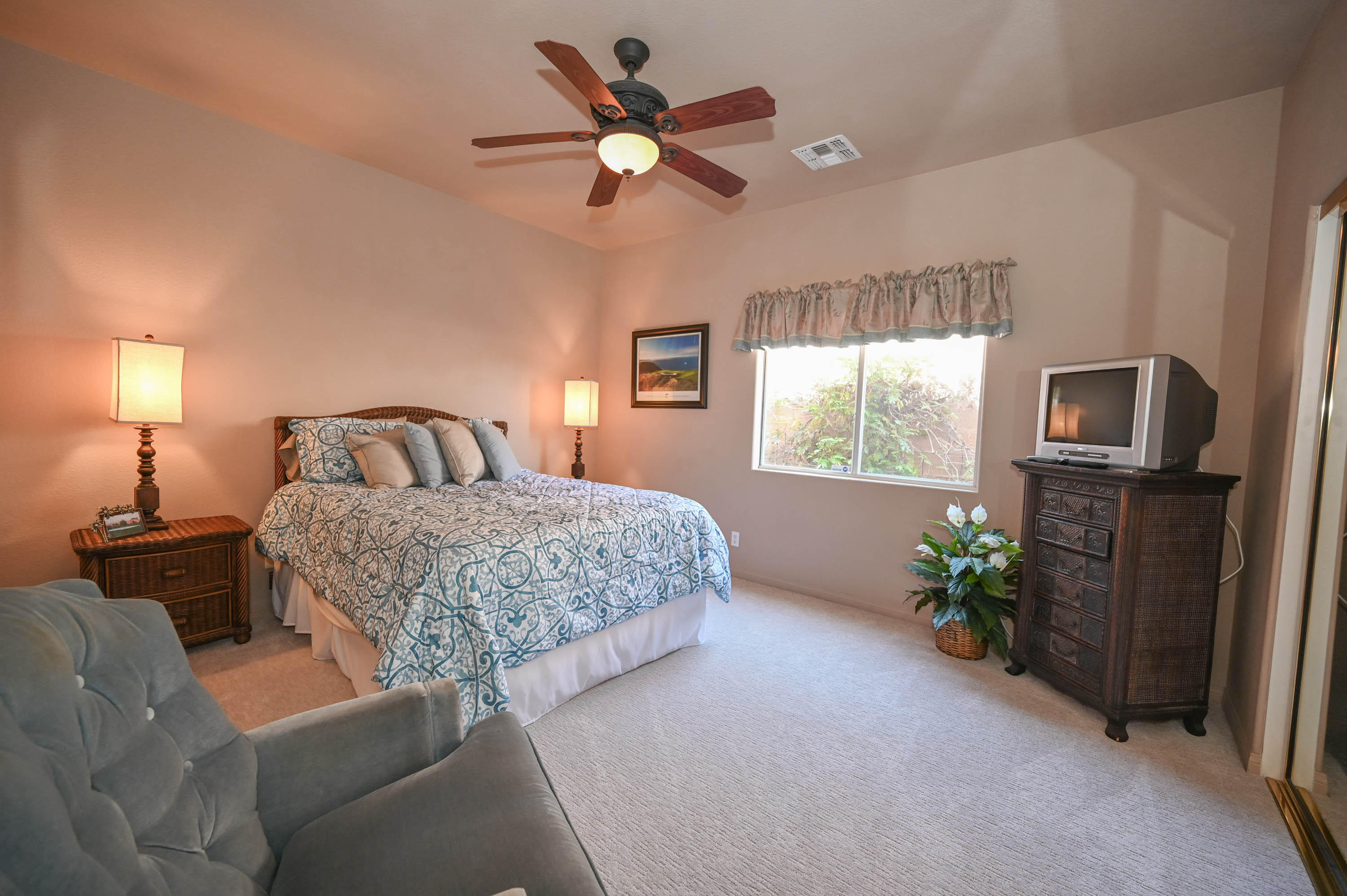 45204 Banff Springs Street Indio, CA 92201 - Photo 30 of 36 a bedroom with a bed potted plant with a chandelier