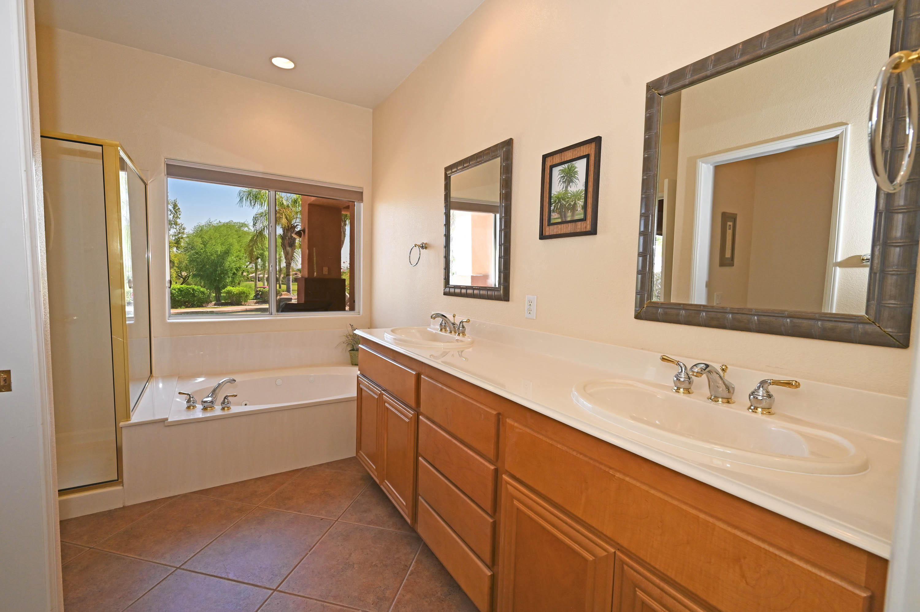 45204 Banff Springs Street Indio, CA 92201 - Photo 34 of 36 a bathroom with a tub double sink window and mirror