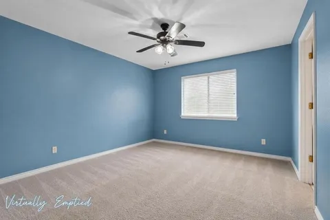 an empty room with windows and ceiling fan