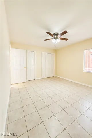 a view of an empty room and chandelier fan