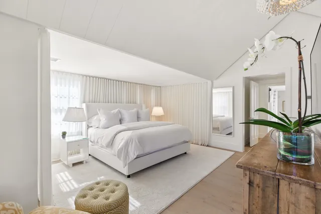 a bedroom with a bed and a potted plant