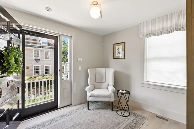 a living room with furniture a window and a potted plant