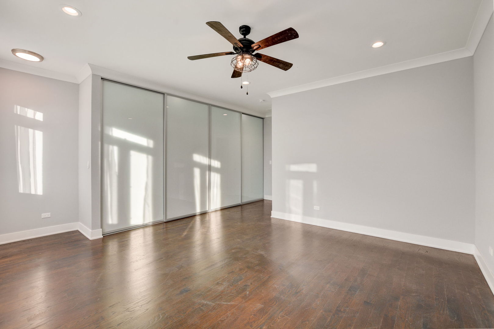 3303 South Racine Avenue Chicago, IL 60608 - Photo 21 of 60 a view of an empty room with a window and wooden floor