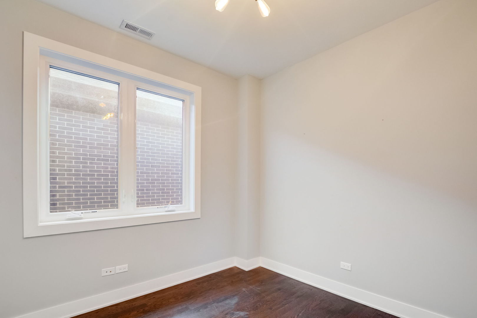 3303 South Racine Avenue Chicago, IL 60608 - Photo 27 of 60 an empty room with wooden floor and windows