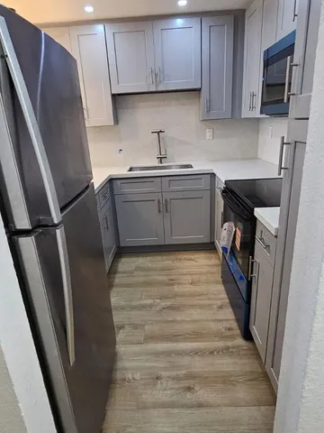 a kitchen with stainless steel appliances granite countertop a refrigerator and a sink