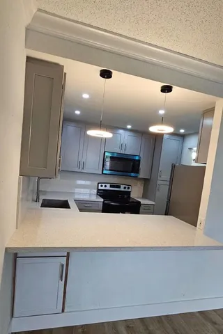 a kitchen with a refrigerator a stove and a microwave