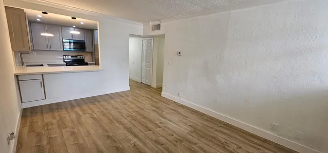 a view of kitchen with wooden floor and electronic appliances