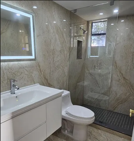 a bathroom with a sink toilet and shower