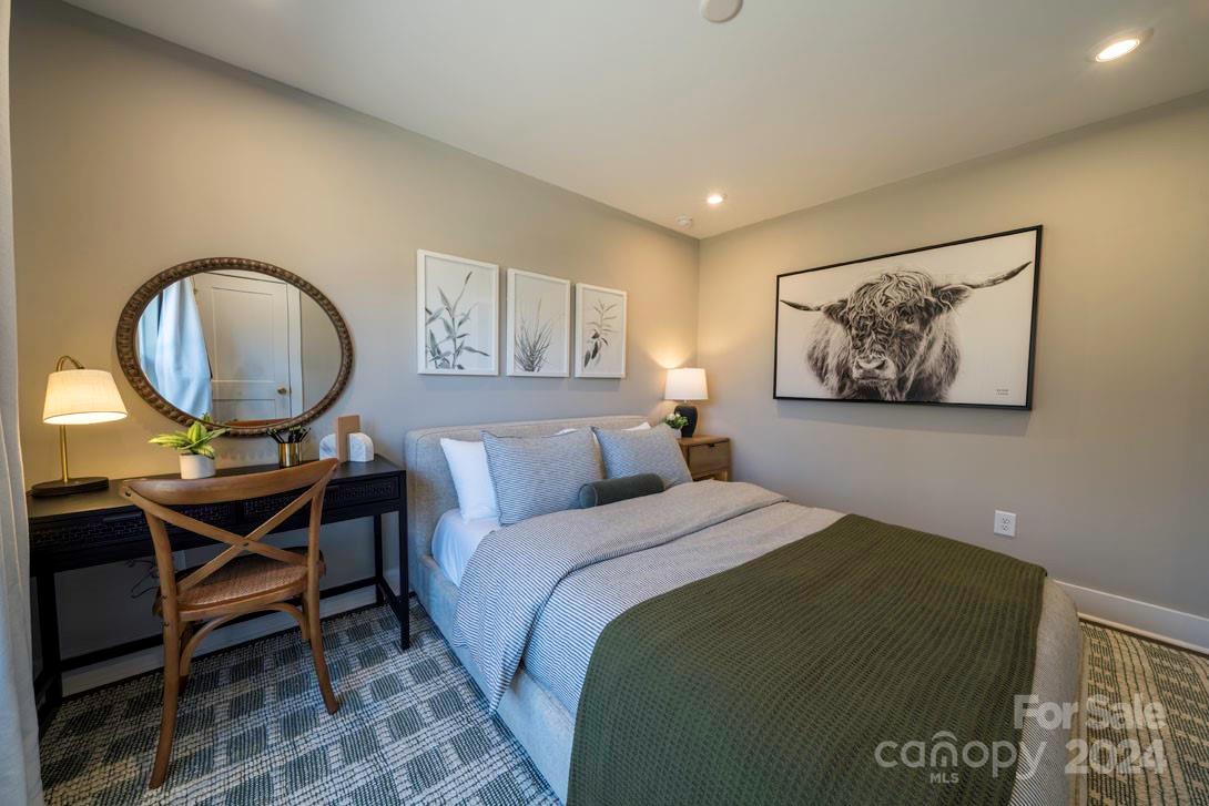2055 Evolve Way Charlotte, NC 28205 - Photo 35 of 40 a bedroom with a bed a mirror and a table