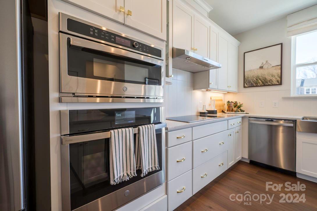 2055 Evolve Way Charlotte, NC 28205 - Photo 10 of 40 a kitchen with granite countertop white cabinets and stainless steel appliances