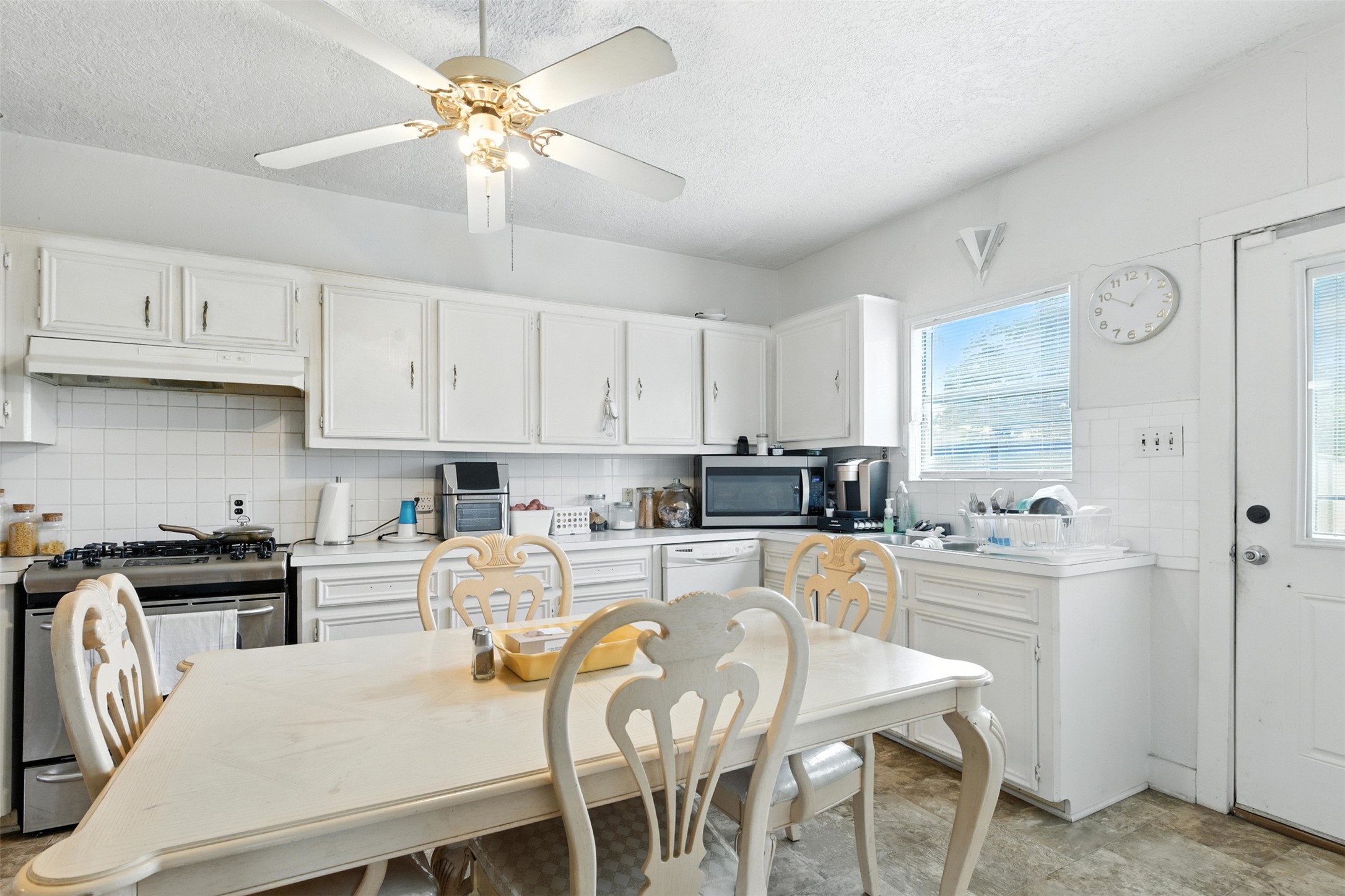 619 10th Street Hempstead, TX 77445 - Photo 12 of 27 a kitchen with stainless steel appliances granite countertop a stove a refrigerator a sink a dining table and chairs with wooden floor