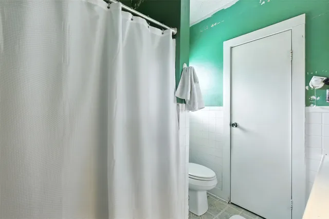 a bathroom with a granite countertop toilet and a shower