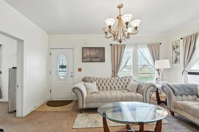 a living room with furniture a chandelier and a window