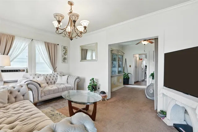 a living room with furniture a chandelier and a flat screen tv