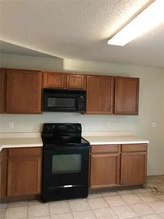 a kitchen with granite countertop a stove top oven and cabinets