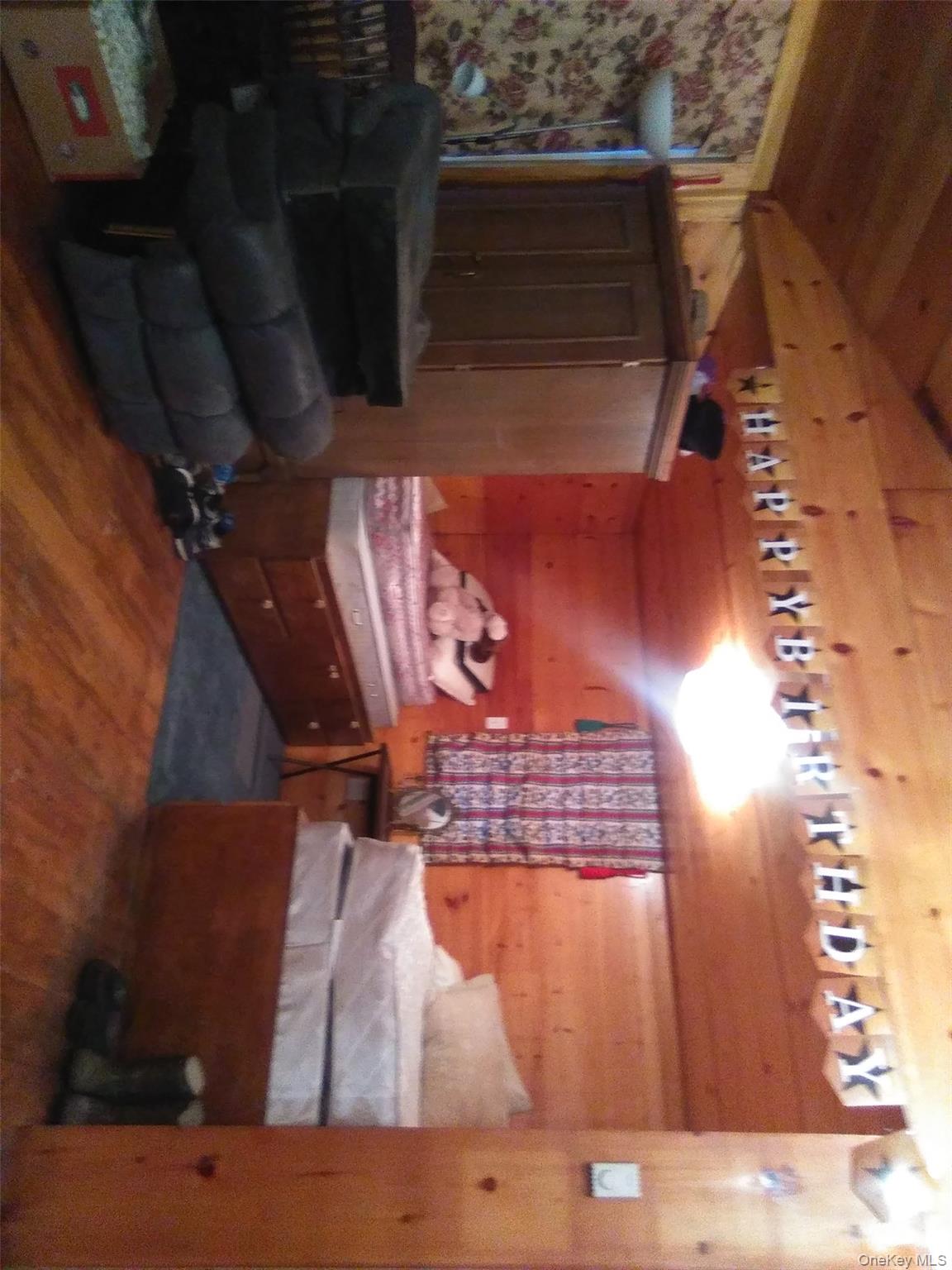 Bedroom featuring wood walls, dark wood-style flooring, wooden ceiling, and lofted ceiling