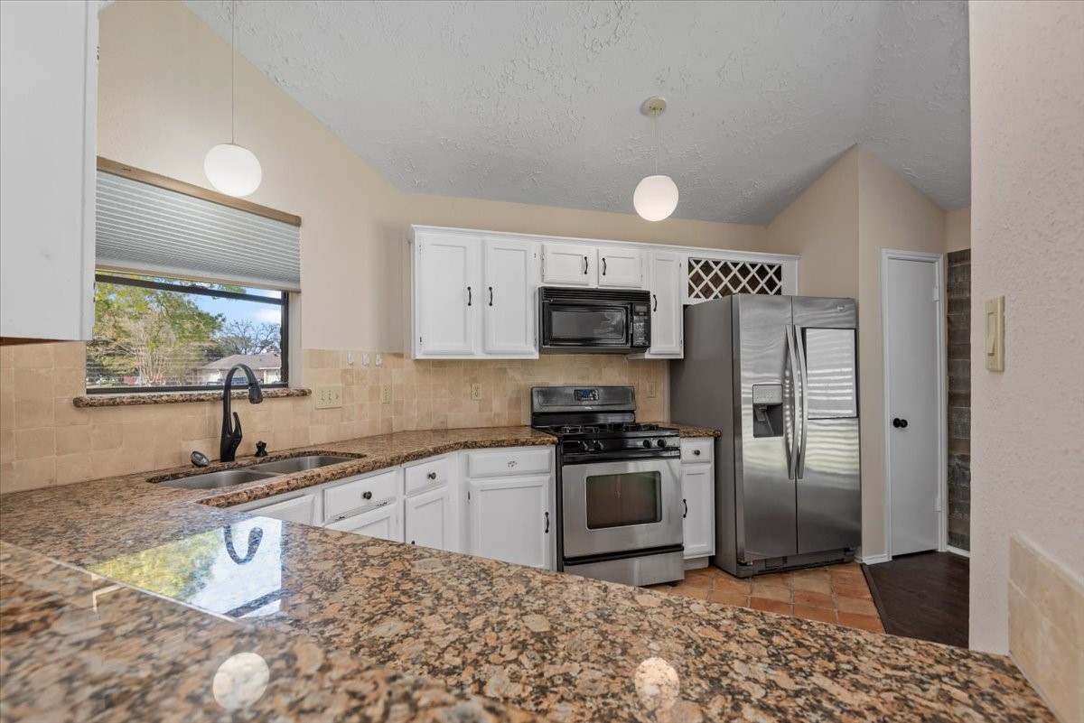 6022 Sean Court Humble, TX 77346 - Photo 9 of 18 a kitchen with stainless steel appliances granite countertop a sink stove and refrigerator