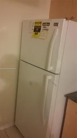 a kitchen with granite countertop a stove a sink and white cabinets