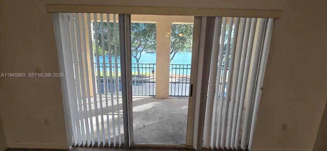 a view of a hallway with wooden floor and a bathroom