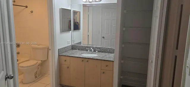 a bathroom with a granite countertop sink a mirror and shower